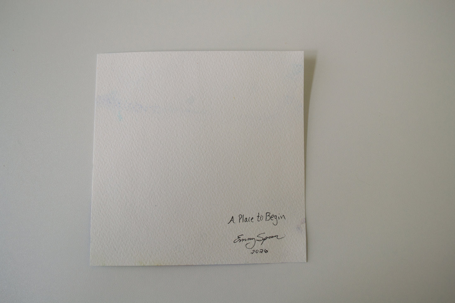 White textured card with text and emmy spoon signature on a light gray background