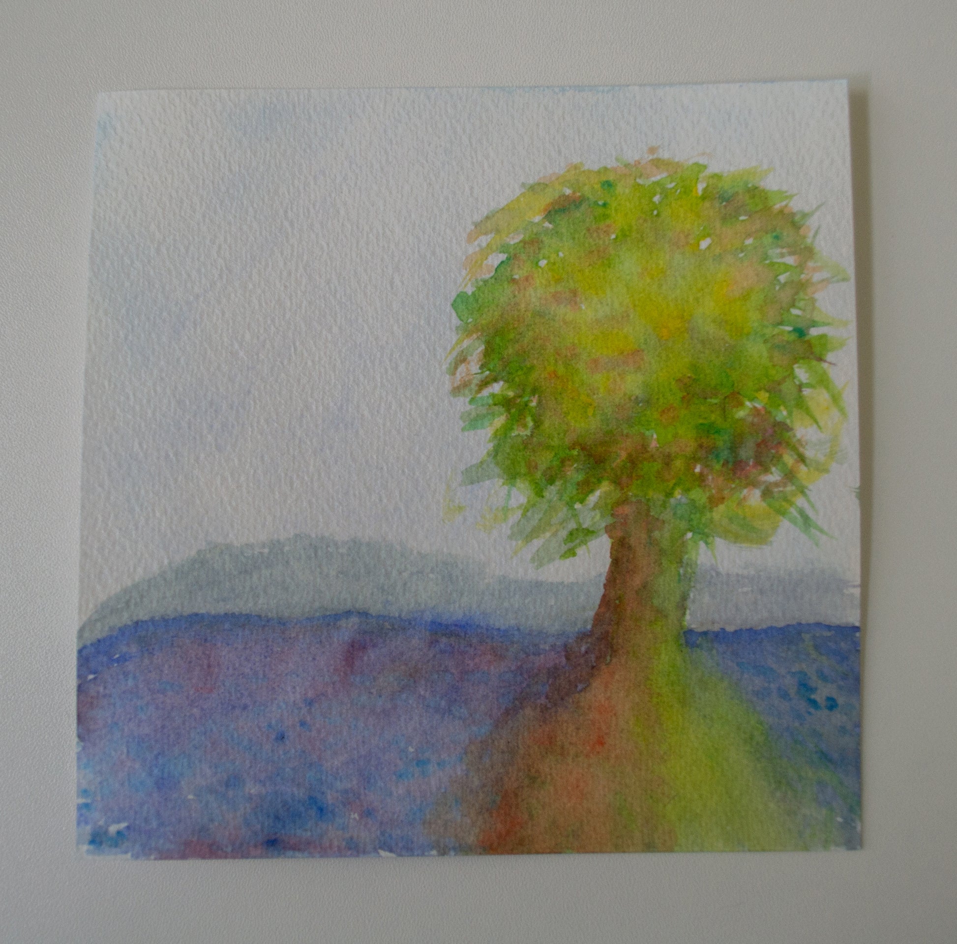 Painting of a tree with a blue landscape in the background