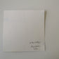 White textured card with text and emmy spoon signature on a light gray background