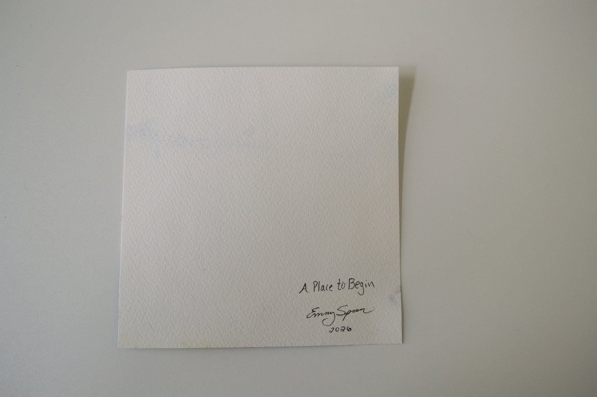 White textured card with text and emmy spoon signature on a light gray background